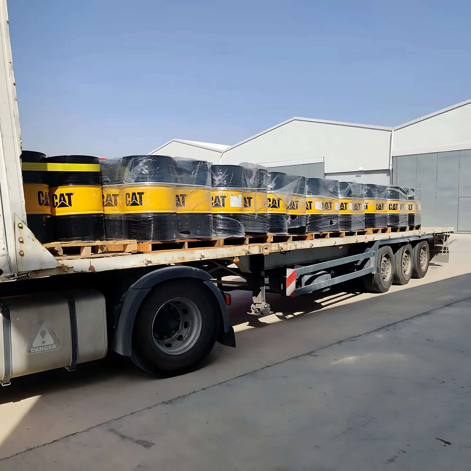 A flatbed truck loaded with palletised Caterpillar lubricant drums at the Desert Rock warehouse