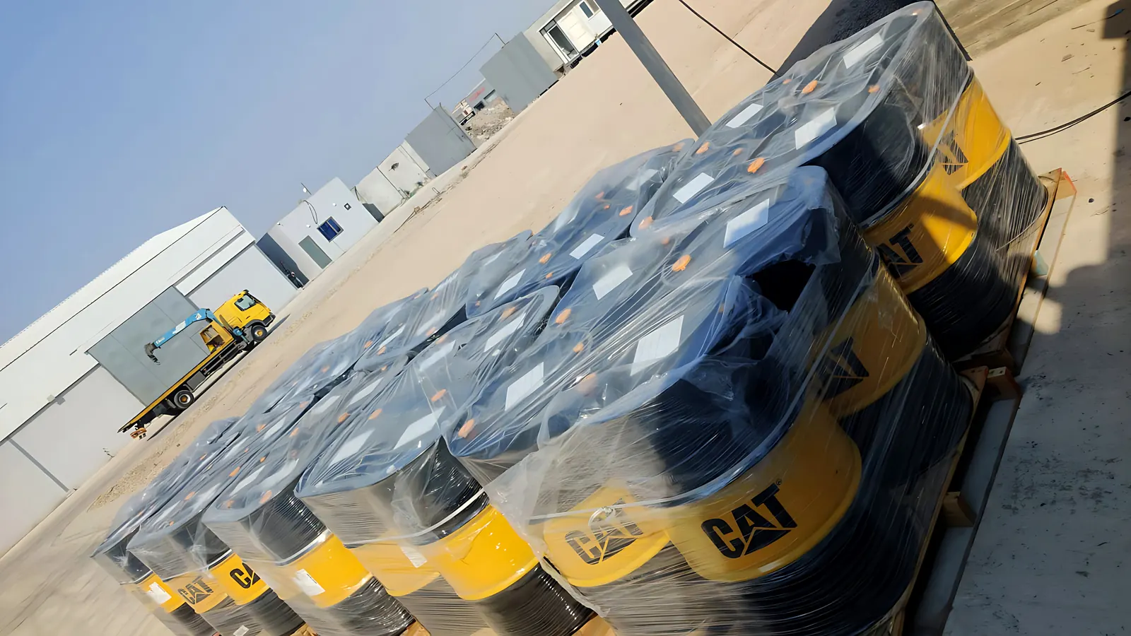 Pallets of genuine Caterpillar lubricant drums, shrink-wrapped outside the Desert Rock warehouse