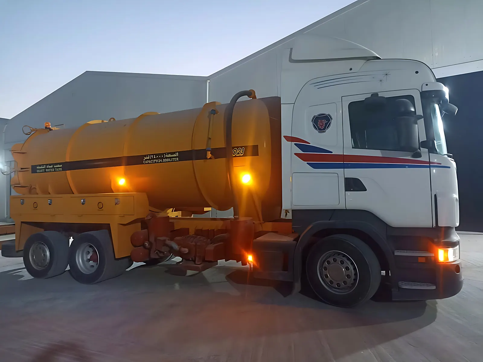 A Desert Rock vacuum truck parked at the warehouse at dusk
